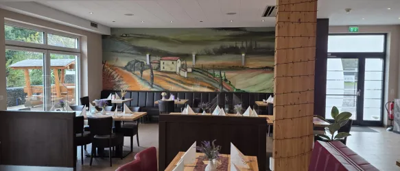 Ein stilvolles Restaurant mit eleganter Einrichtung und einem großen Wandgemälde. Die Atmosphäre ist einladend und gemütlich.