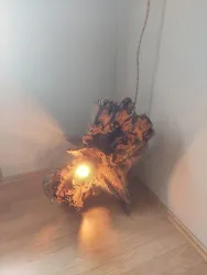 Eine kreative Lampe aus einem Holzstück mit warmem Licht. Der rustikale Stil gibt dem Raum einen natürlichen Touch.