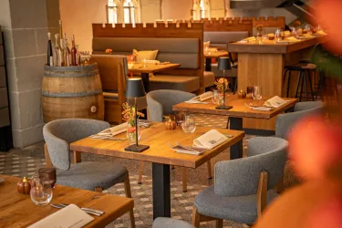Ein stilvolles Restaurant mit Holztafeln und gemütlichen Tischen. Die Einrichtung ist modern und einladend.