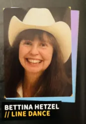 Ein Porträt einer lächelnden Frau mit einem weißen Cowboyhut. Sie heißt Bettina Hetzel und ist mit Line Dance verbunden.