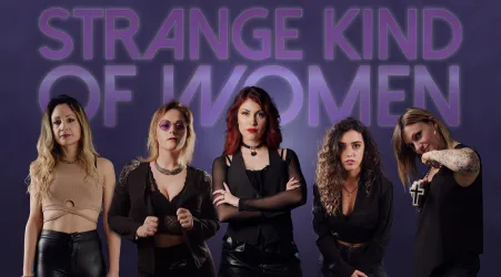 Eine Gruppe von fünf Frauen in stylischen, dunklen Outfits posiert vor einem lila Hintergrund. Der Schriftzug "STRANGE KIND OF WOMEN" steht prominent im Bild.