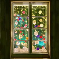 Ein festlich dekoriertes Fenster mit bunten Ornamenten und Lichtern. Im Hintergrund ist ein grüner Weihnachtsbaum zu sehen.