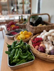 Ein Tisch voller frischer Gemüse und Obstsorten. Es gibt grüne Chilis, Zitronen, Zwiebeln und viele andere gesunde Zutaten.