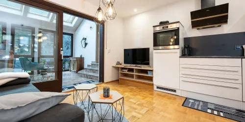 Wohnzimmer mit TV und Küche